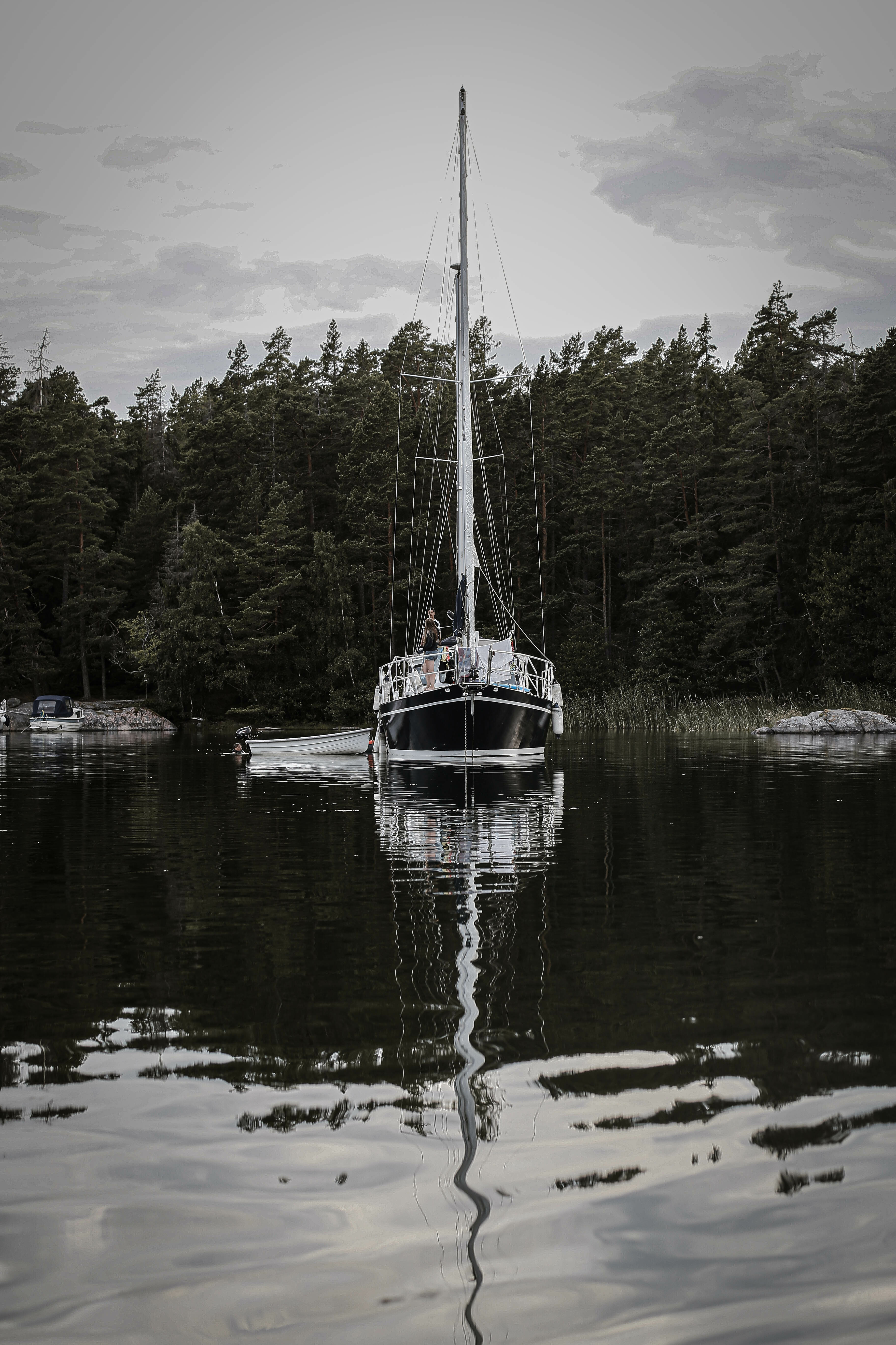 En sejlbåd ligger på et spejlblankt hav i Stockholms skærgård